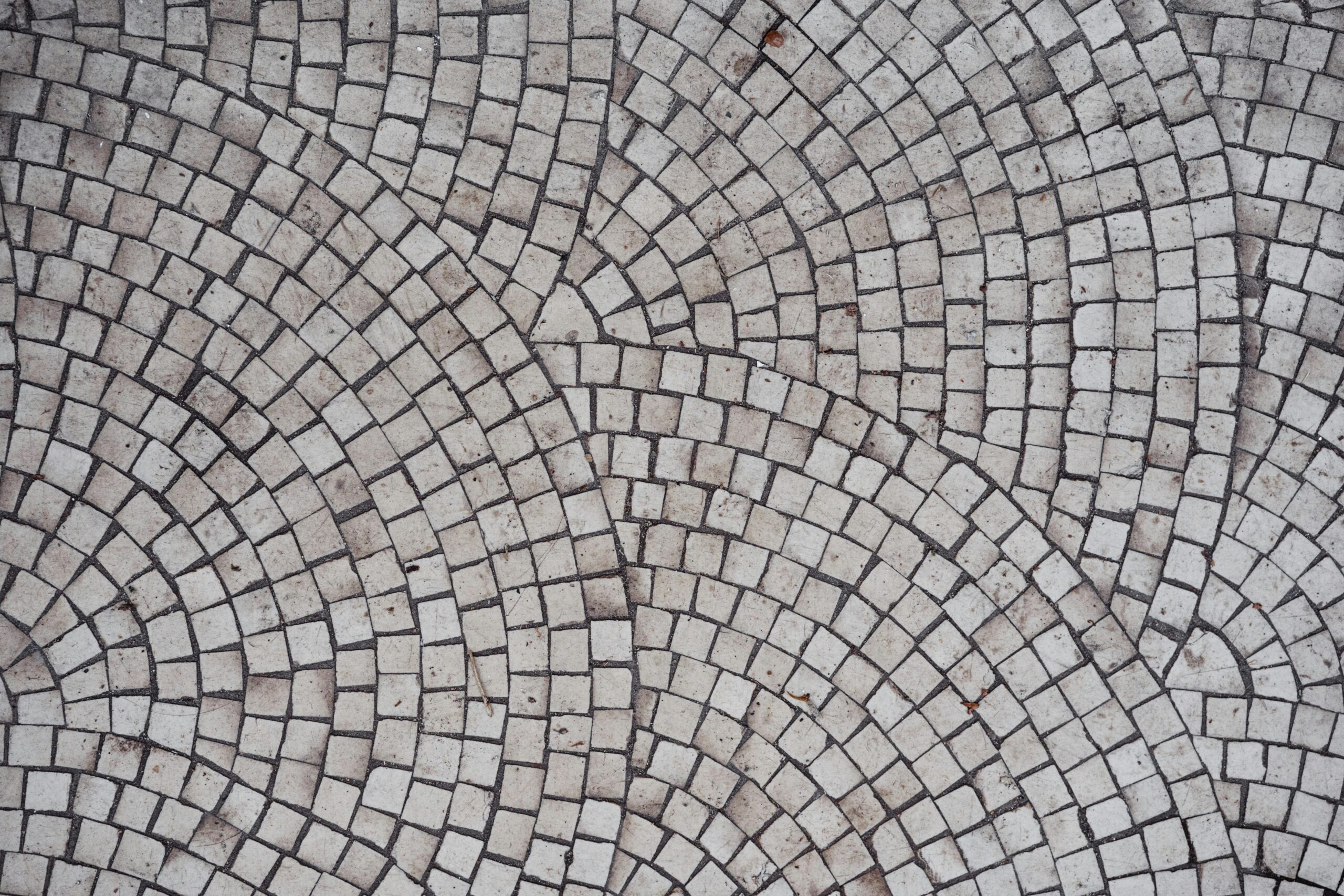 Detailed view of a geometric mosaic tile pattern with circular designs creating an artistic pavement.